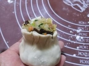 在利用虎口，将烧麦收口，掐出腰身，一个烧麦就做好了。