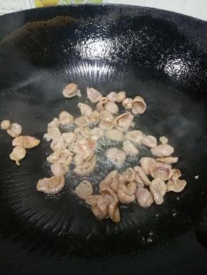 油八成热后加入香肠，煸炒至变色。