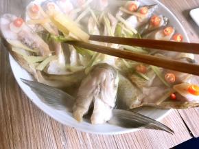 将蒸好的孔雀开屏鱼端出锅，将姜丝、葱段丢弃