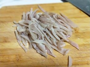 之后用刀把肉皮上的油脂刮干净。再将肉皮切丝，之后再切肉皮丁。