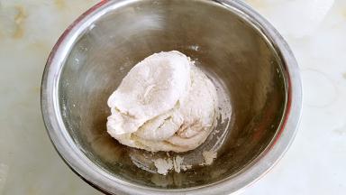 用手揉面，这个时候面团较硬，无法成型，盖上保鲜膜醒发10分钟。