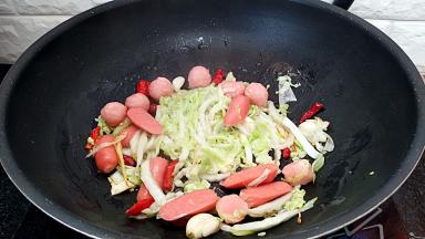 倒入丸子和肉肠煸炒几下。