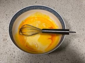 再倒入牛奶和玉米油搅打均匀
