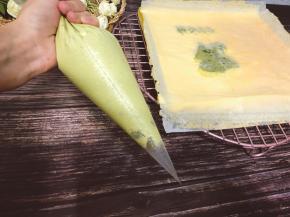 把夹馅倒入裱花袋中，均匀挤入蛋糕的没有青蛙那一面，抹匀