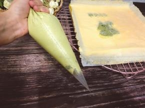 把夹馅倒入裱花袋中，均匀挤入蛋糕的没有青蛙那一面，抹匀