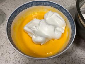 蛋白霜先分两次刮入蛋黄糊内（剩一份），每一次都要翻拌均匀再加入下一次