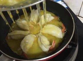 把蛋液通过漏勺均匀的倒在虾饺上。（没有漏勺，直接把蛋液倒进锅里也可。）