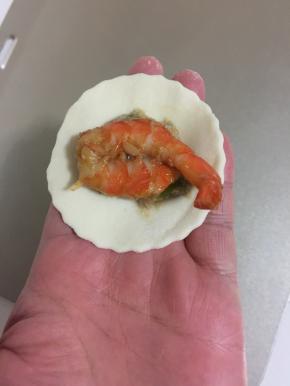 在肉馅儿上放入一只腌制好的虾。