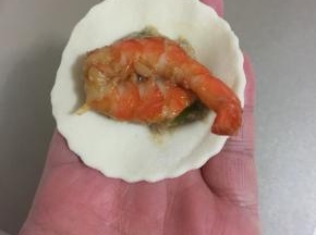 在肉馅儿上放入一只腌制好的虾。