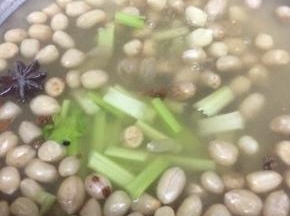在将芹菜放入煮花生米的锅中，在煮开锅三分钟
