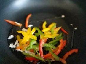 起油锅，加入蒜炒香，之后加入彩椒丝。