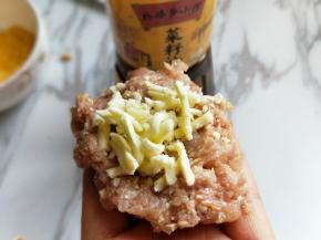 取肉糜放手心，放上马苏里拉。包起来，揉圆。