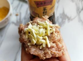 取肉糜放手心，放上马苏里拉。包起来，揉圆。
