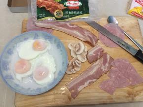 然后捞出水波蛋备用，培根、火腿片切块，白蘑菇切片