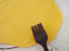 将面团擀开，刷上一层蛋液。