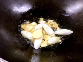 锅烧热油，爆香姜、蒜片和葱段