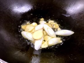 锅烧热油，爆香姜、蒜片和葱段