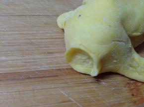 头部用手捏出一个圆形的小沿作为嘴部