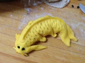 最后在鱼两侧安装黑豆作为眼睛，在鱼嘴两边各剪一下作为鱼须，鱼尾部弯折整形完成