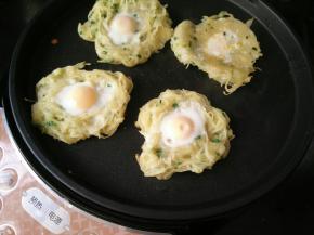 在每个土豆丝中间敲入一个鹌鹑蛋。