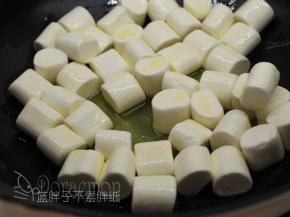 加入棉花糖，先大致翻拌一下，让每一颗棉花糖表面都沾满黄油。