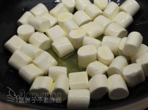 加入棉花糖，先大致翻拌一下，让每一颗棉花糖表面都沾满黄油。