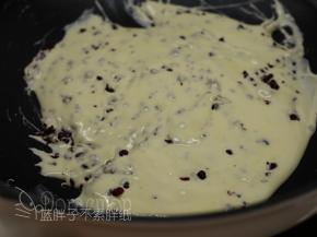 倒入蔓越莓干，用刮刀快速地将它们混匀。