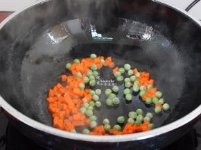 热锅倒油，煸香胡萝卜粒和甜豆；