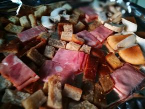 将土司丁 培根和蘑菇放入烤盘 淋些橄榄油 少许盐 胡椒粉 入烤箱200℃烤制10-15分钟