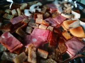 将土司丁 培根和蘑菇放入烤盘 淋些橄榄油 少许盐 胡椒粉 入烤箱200℃烤制10-15分钟