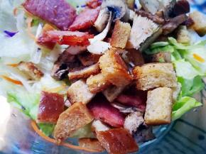 将烤好的土司丁等倒入生菜中 搅拌均匀