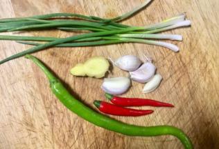 猪心煮的时候，我们准备凉拌佐料，美人椒和红尖椒切细小节，香葱切葱花，大蒜老姜剁泥