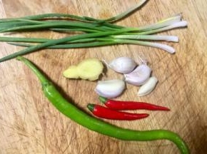 猪心煮的时候，我们准备凉拌佐料，美人椒和红尖椒切细小节，香葱切葱花，大蒜老姜剁泥