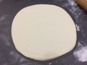 用擀面杖从饼的中间开始擀，然后在一起翻到另外一面擀，擀成大圆饼