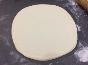 用擀面杖从饼的中间开始擀，然后在一起翻到另外一面擀，擀成大圆饼