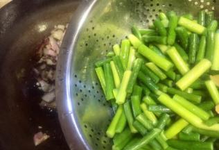 腊肉推在锅的一遍，再放入蒜苔