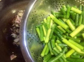 腊肉推在锅的一遍，再放入蒜苔