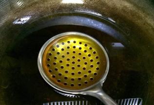 锅里倒入较多的油，最好能淹没漏勺，漏勺在热油里加热