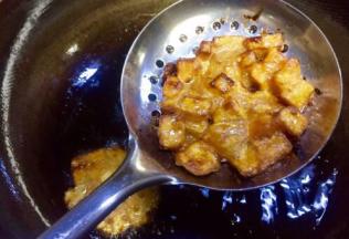 待到焦黄时逐个捞起沥干油水