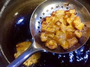 待到焦黄时逐个捞起沥干油水