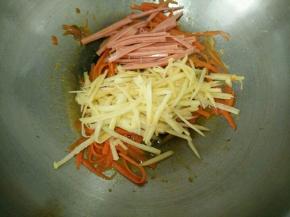 加入火腿肠和土豆丝，再放适量盐调味。