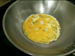 锅烧热放适量油，倒一半的鸡蛋液，一边晃动炒锅，让鸡蛋液变大变薄。