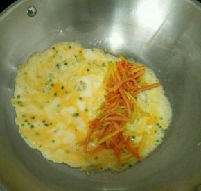 待底下蛋液凝固后，把刚才炒好的三丝摆在蛋饼的三分之一处。(如图)