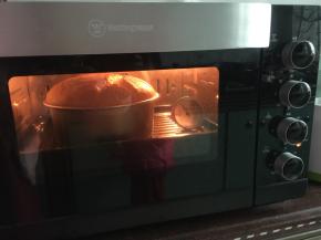 然后距离模具20cm倒入模具中震泡两次，放入预热好的烤箱中层，150摄氏度上下火烤40分钟