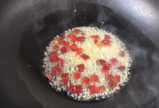 热锅凉油，放入姜末和辣椒，炒出香味。