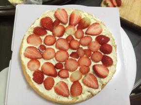 蛋糕切两片后取一片抹上打发好的奶油，放入切片的草莓