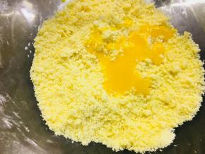 将蛋黄液倒入搓好的黄油颗粒中