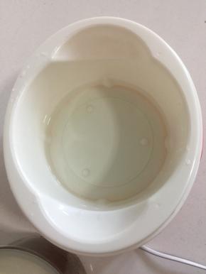 酸奶机中倒入大约一指厚度的温水。（水不要太热，用手摸一下，不烫手即可。）
