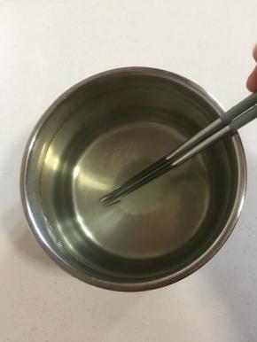 把砂糖倒进容器中，加入温水搅拌均匀至砂糖融化。