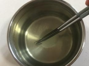 把砂糖倒进容器中，加入温水搅拌均匀至砂糖融化。